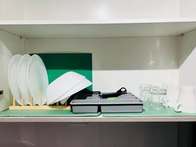 a shelf with white plates and glasses on it at 1BR Condotel with Balcony at FAME Residences #FM19 in Manila