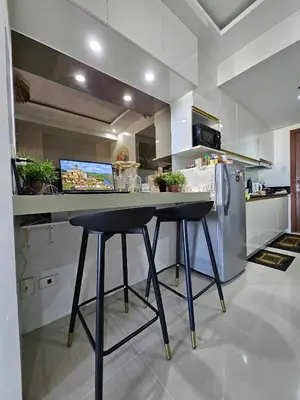 a kitchen with a table and a refrigerator at 1 Bedroom Condo Unit Near MOA with Netflix and WIFI in Manila