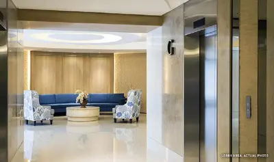 a lobby with a blue couch and chairs at 1 Bedroom Condo Unit Near MOA with Netflix and WIFI in Manila