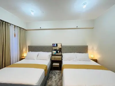 two beds in a small room with a desk at Jasrich Suite Behind SM trece martires HOPE RESIDENCES SMDC in Cavite