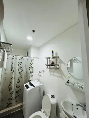 a bathroom with a toilet and a sink and a mirror at Jasrich Suite Behind SM trece martires HOPE RESIDENCES SMDC in Cavite