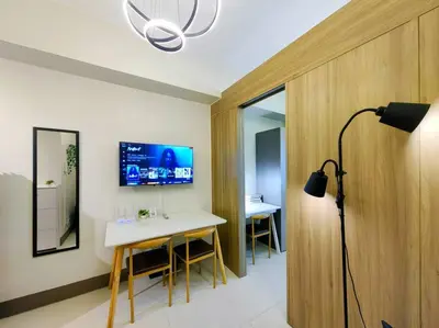 a room with a desk and a tv on the wall at 1BR Condotel with Balcony FAME Residences #FM24 in Manila