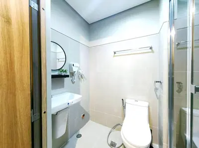 a bathroom with a toilet and a sink and a shower at 1BR Condotel with Balcony FAME Residences #FM24 in Manila