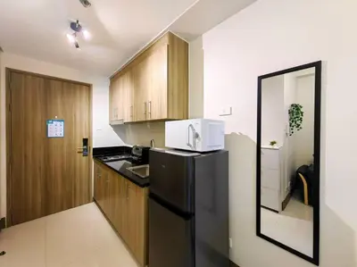 a kitchen with a black refrigerator and a microwave at 1BR Condotel with Balcony FAME Residences #FM24 in Manila