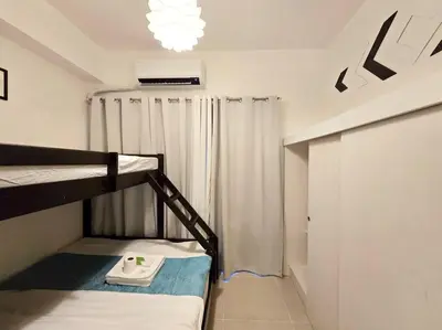 a room with two bunk beds and a chandelier at 1BR Condotel with Balcony at FAME Residences #FM40 in Manila