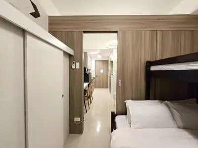 a bedroom with a bed and a dining room at 1BR Condotel with Balcony at FAME Residences #FM40 in Manila