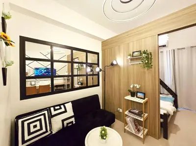 a living room with a black couch in a room at 1BR Condotel with Balcony at FAME Residences #FM40 in Manila