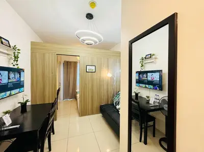 a living room and a dining room with a table at 1BR Condotel with Balcony at FAME Residences #FM41 in Manila