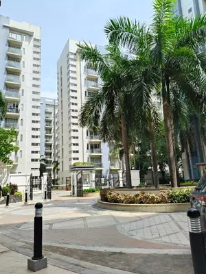 a parking lot with palm trees and buildings at LDN Secret Crib - Two Palm Tree Newport City in Manila
