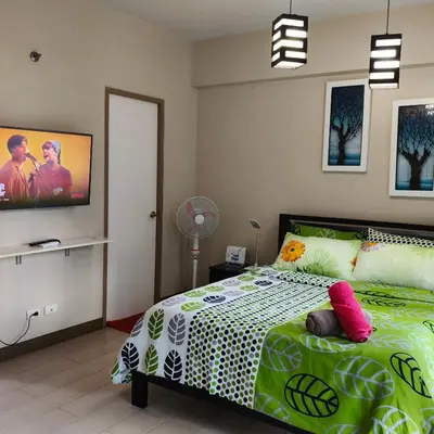 a bedroom with a bed and a tv on the wall at LDN Secret Crib - Two Palm Tree Newport City in Manila