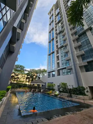 a man in a swimming pool in front of a building at Affordable Condo Suite with 150mbps WIFI in Manila