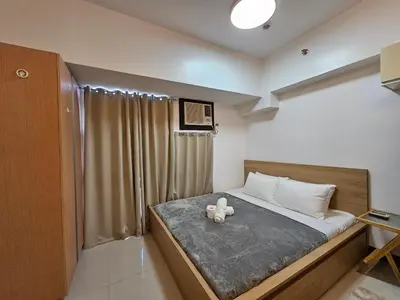 a bedroom with a bed with a teddy bear on it at Affordable Condo Suite with 150mbps WIFI in Manila