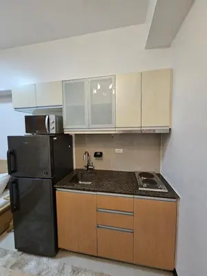 a kitchen with a black refrigerator and a sink at Affordable Condo Suite with 150mbps WIFI in Manila