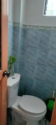 a bathroom with a toilet and a blue tiled wall at 3J's Place in General Trias