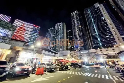 a city at night with cars parked in a parking lot at BGC Staycation: 1BR Condo Uptown Area #ournw12d in Manila