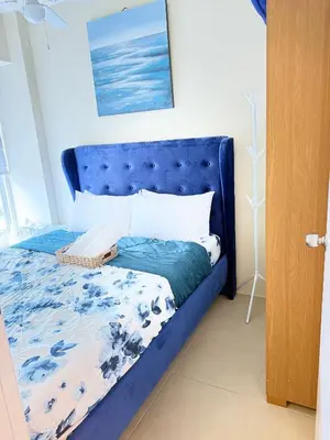 a bed with a blue headboard in a room at Meteor Suites in Manila