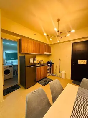 a kitchen with a table and a black refrigerator at Meteor Suites in Manila