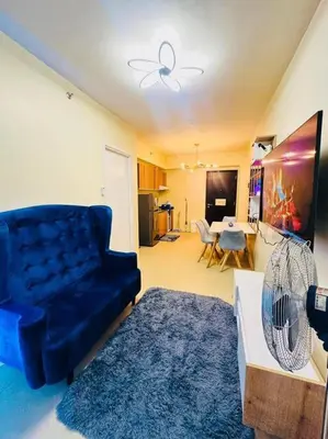a living room with a blue couch and a table at Meteor Suites in Manila