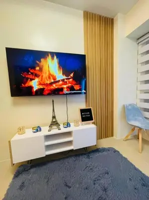 a living room with a tv with a fire on the wall at Meteor Suites in Manila