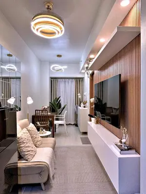 a living room with a couch and a tv on a wall at The 3rd Staycation Near MOA, Airport, with FREE WIFI, Netflix in Manila