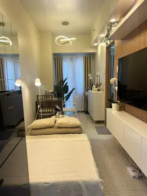 a living room with a bed and a television at The 3rd Staycation Near MOA, Airport, with FREE WIFI, Netflix in Manila
