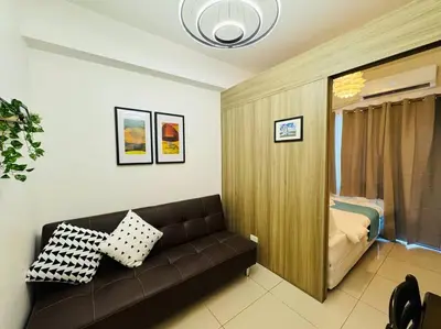 a living room with a couch and a bed at 1BR Condotel with Balcony at FAME Residences #FM42 in Manila