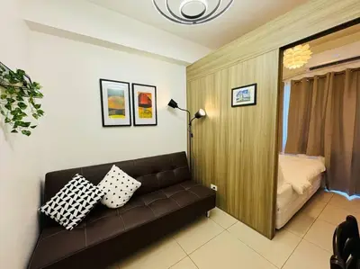 a living room with a couch and a bed at 1BR Condotel with Balcony at FAME Residences #FM42 in Manila