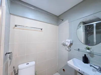 a bathroom with a toilet and a sink and a mirror at 1BR Condotel with Balcony at FAME Residences #FM43 in Manila