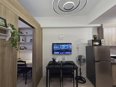 a dining room with a table and a kitchen at 1BR Condotel with Balcony at FAME Residences #FM43 in Manila