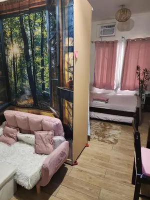 a living room with a couch and a bed at Condotel Near NAIA - massage chair footspa, dance revo, small pet allowed in Manila