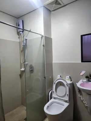a bathroom with a toilet and a shower and a sink at Condotel Near NAIA - massage chair footspa, dance revo, small pet allowed in Manila
