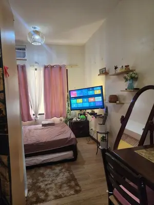 a bedroom with a bed and a computer monitor at Condotel Near NAIA - massage chair footspa, dance revo, small pet allowed in Manila