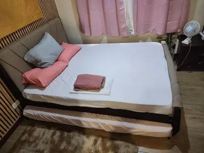 a bed with three pillows on it in a room at Condotel Near NAIA - massage chair footspa, dance revo, small pet allowed in Manila