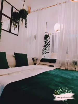 a bedroom with a large bed with white curtains at El Nissi Staycation, THE GARDEN CABIN, Enchanted Kingdom in Santa Rosa