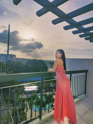 a woman in a red dress standing on a balcony at El Nissi Staycation, THE GARDEN CABIN, Enchanted Kingdom in Santa Rosa