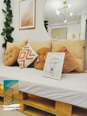 a couch with pillows and a sign on it at El Nissi Staycation, THE COLOR CABIN, Enchanted Kingdom in Santa Rosa