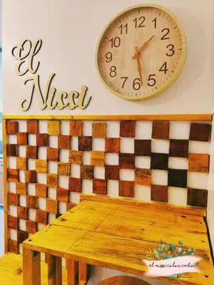 a clock on a wall above a wooden table at El Nissi Staycation, THE COLOR CABIN, Enchanted Kingdom in Santa Rosa