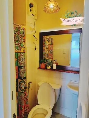 a bathroom with a toilet and a sink and a mirror at El Nissi Staycation, THE COLOR CABIN, Enchanted Kingdom in Santa Rosa