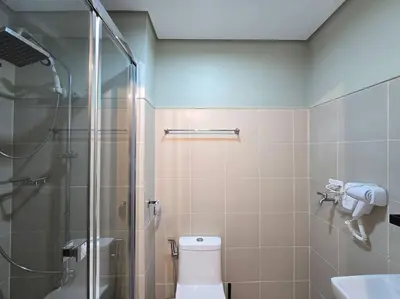a bathroom with a shower and a toilet and a sink at 1BR Condotel with Balcony at FAME Residences #FM44 in Manila