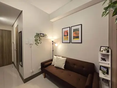 a living room with a couch and a lamp at 1BR Condotel with Balcony at FAME Residences #FM50 in Manila