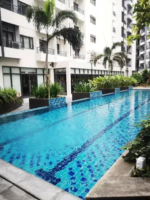 a swimming pool in front of a building at SPRING RESIDENCES - 2BR Condo near Airport with balcony and pool views in Manila
