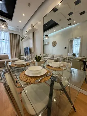 a dining room with a glass table and chairs at Minimalist Luxury Spacious 1 Bedroom in Burgos Circle in Manila