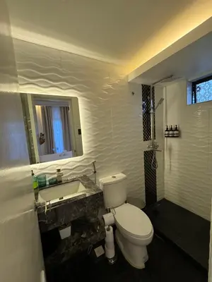 a bathroom with a toilet and a sink at Minimalist Luxury Spacious 1 Bedroom in Burgos Circle in Manila