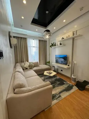 a living room with a couch and a tv at Minimalist Luxury Spacious 1 Bedroom in Burgos Circle in Manila