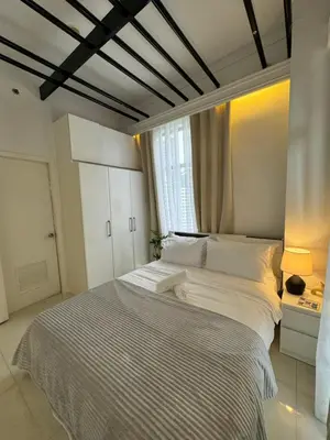 a bedroom with a large white bed with a window at Minimalist Luxury Spacious 1 Bedroom in Burgos Circle in Manila
