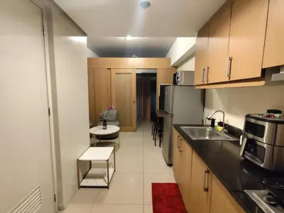 a kitchen with a sink and a refrigerator at Angelica Staycation at Mall of Asia Shell Residence in Manila
