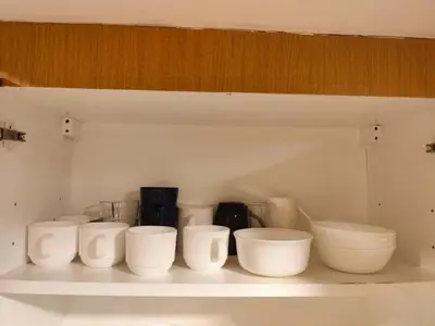 a row of white bowls on a shelf at Angelica Staycation at Mall of Asia Shell Residence in Manila
