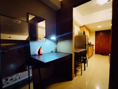 a room with a kitchen with a desk and a refrigerator at Angelica Staycation at Mall of Asia Shell Residence in Manila