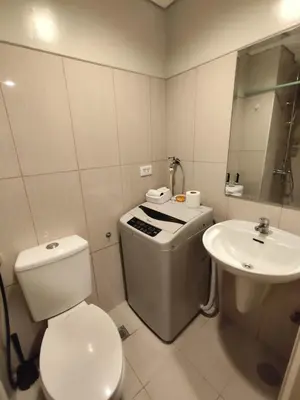 a white bathroom with a toilet and a sink at Angelica Staycation at Mall of Asia Shell Residence in Manila