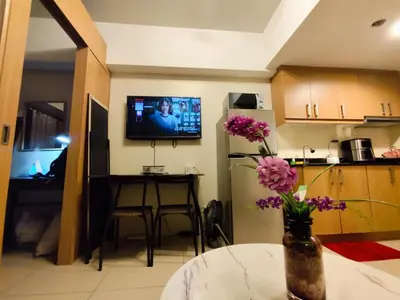 a kitchen with a table with flowers in a vase at Angelica Staycation at Mall of Asia Shell Residence in Manila